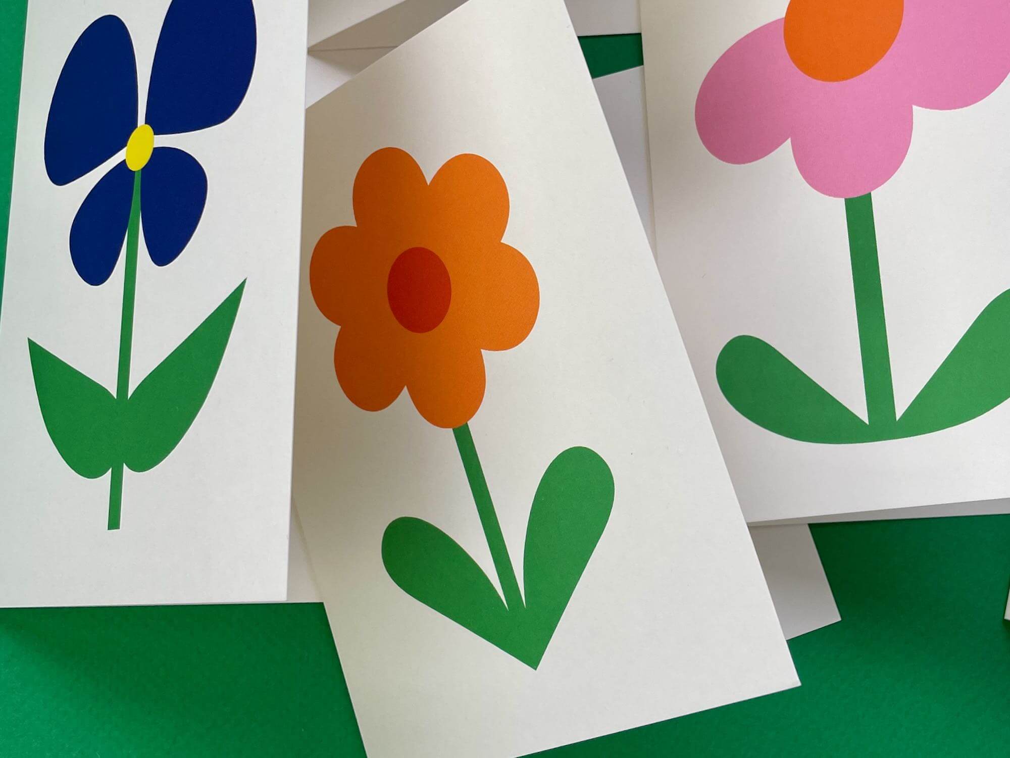 three cards with flowers cut out of them