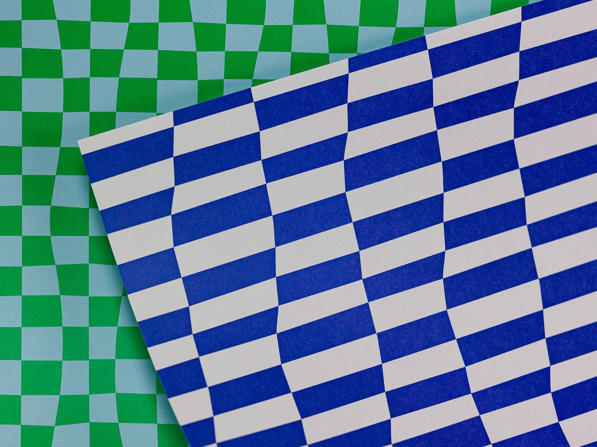 a blue and white checkered paper is laying on a green and white checkered