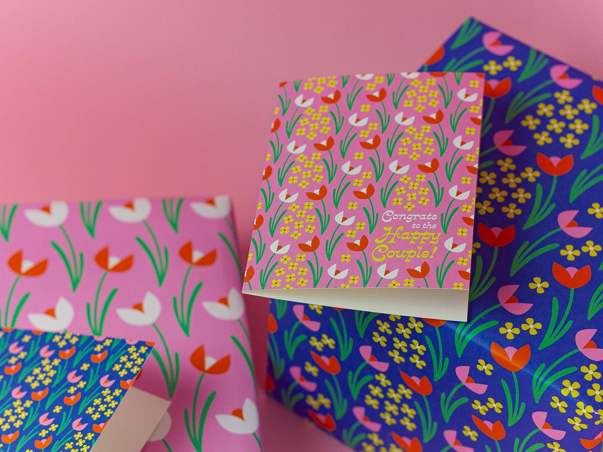 Vintage inspired red and pink tulip pattern wedding card with retro typography with matching wrapped gifts.