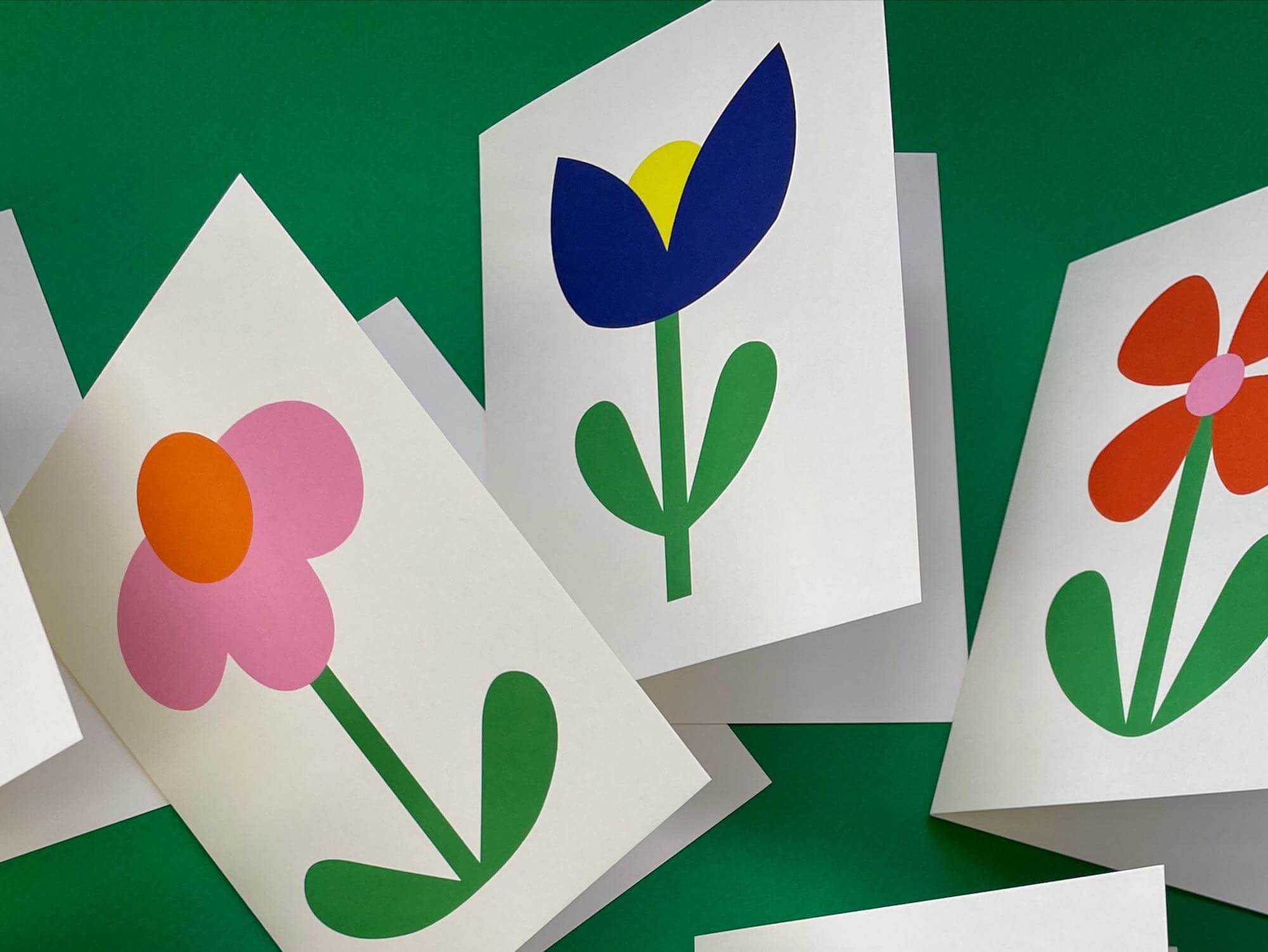 four cards with flowers cut out of them