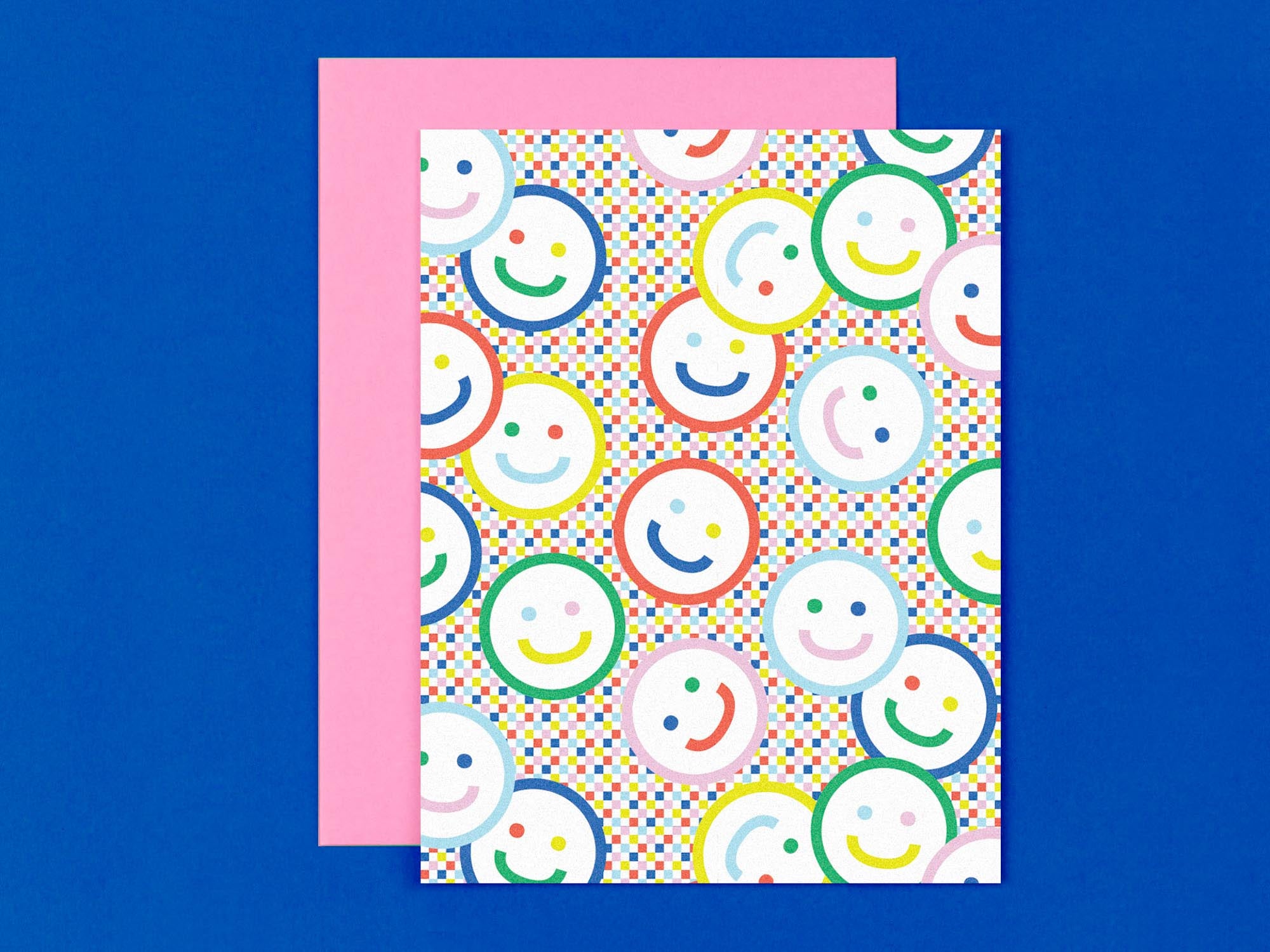 "Check yr smile" blank pattern greeting card with smiley faces against a rainbow checker background. Made in USA by @mydarlin_bk