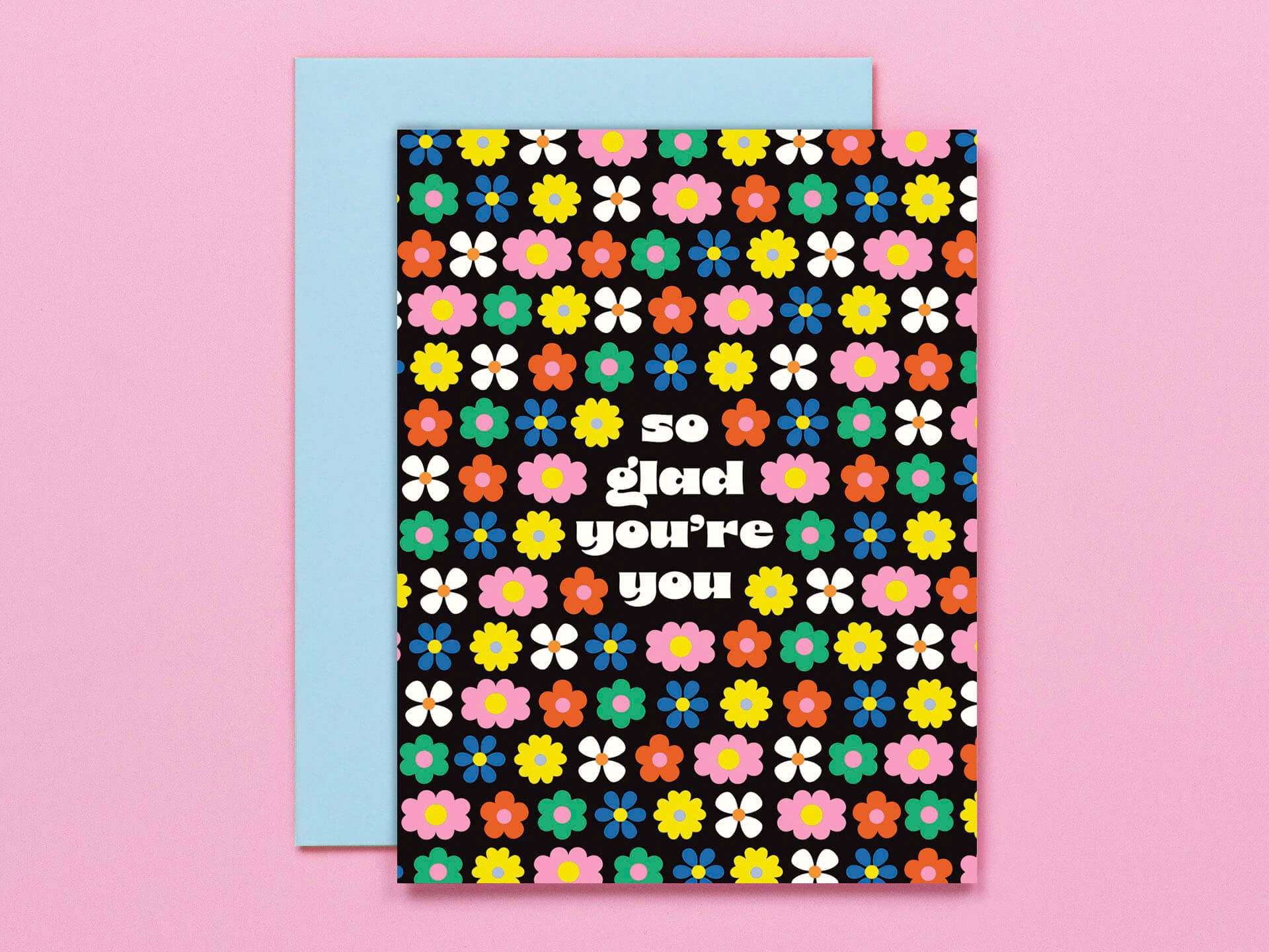 A colorful greeting card with a floral pattern and the text 'So Glad You're You' on it, paired with a coordinating envelope.