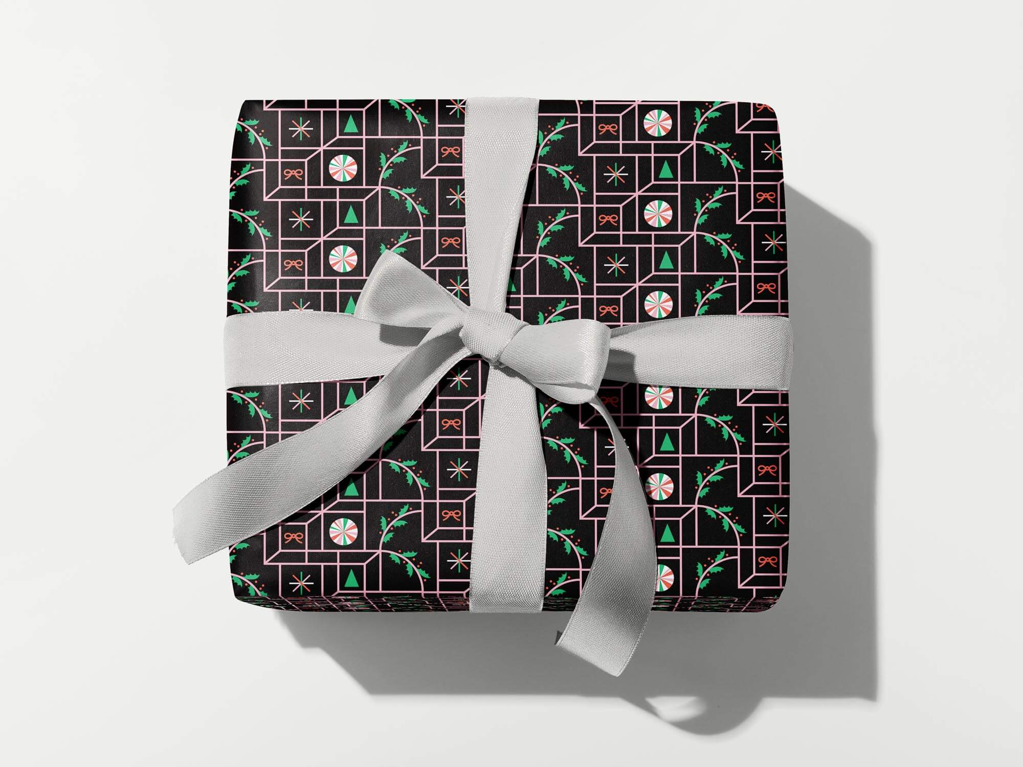 Mid-century and op art inspired optical illusion wrapping paper with pattern of peppermints, holly, bows, Christmas trees, and twinkly stars.