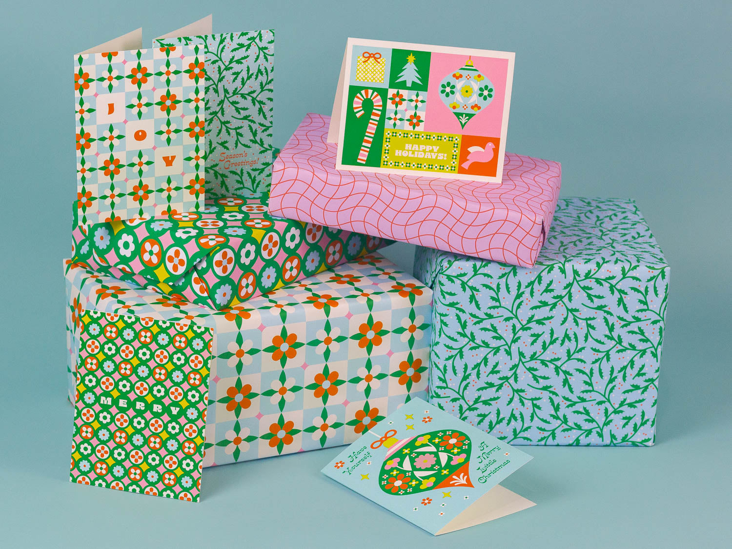 Stack of retro floral holiday cards and wrapped gifts that are part of our Blue Christmas collection.
