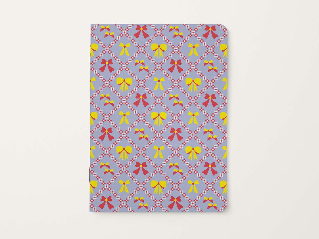 Notebook with a floral harlequin pattern of colorful bows on a light blue background