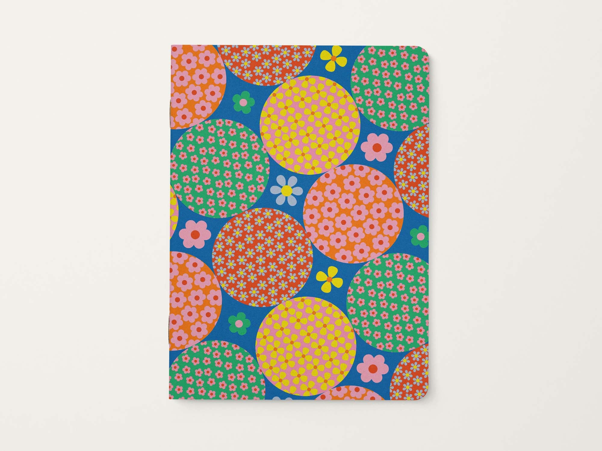 Notebook with colorful circular retro floral pattern on a blue background