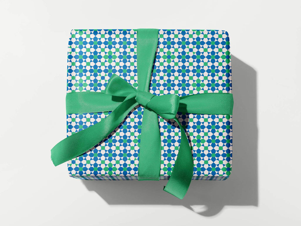 a present wrapped in blue and white paper with a green bow