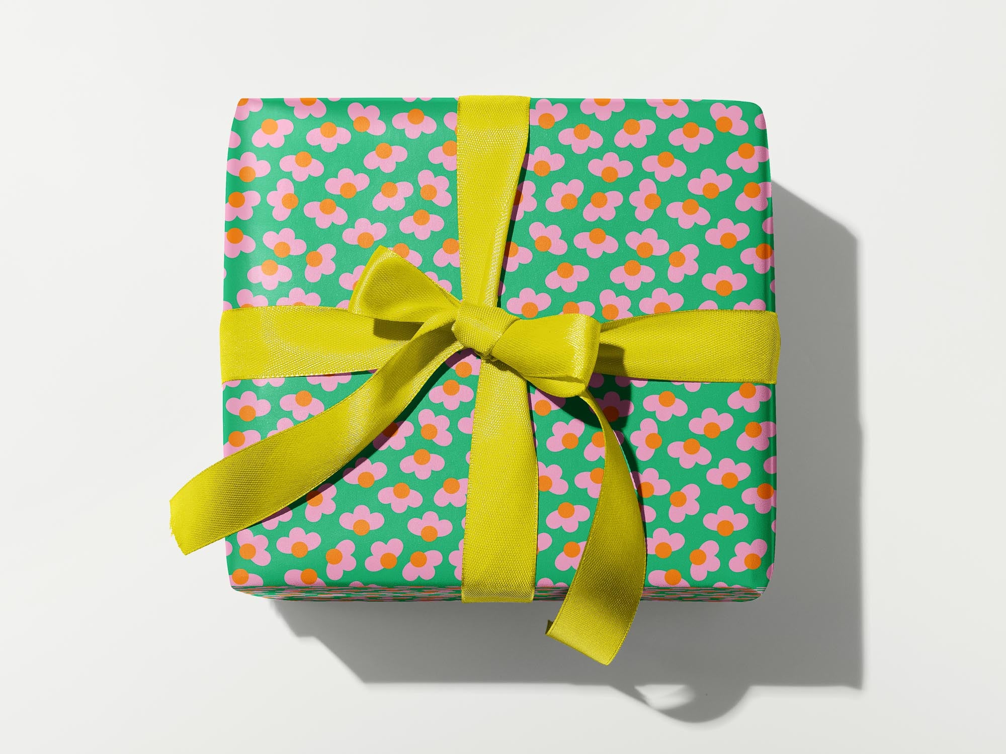 a present wrapped in green and pink paper with a yellow bow
