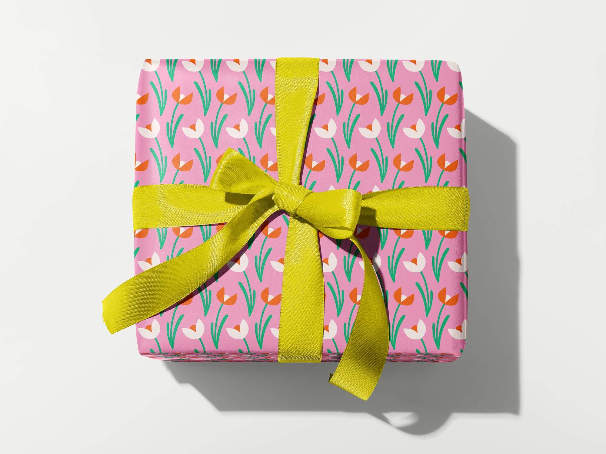 a present wrapped in pink and green with a yellow bow